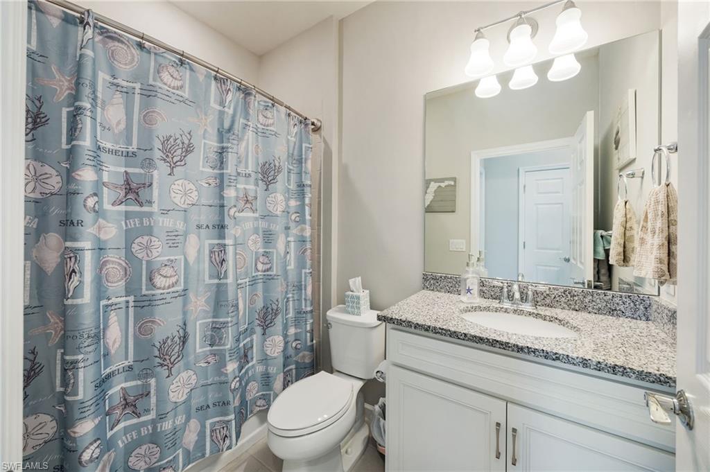 6125 Triumph Lane Ave Maria, FL 34142 - Photo 18 of 45 a bathroom with a granite countertop sink a toilet and a mirror