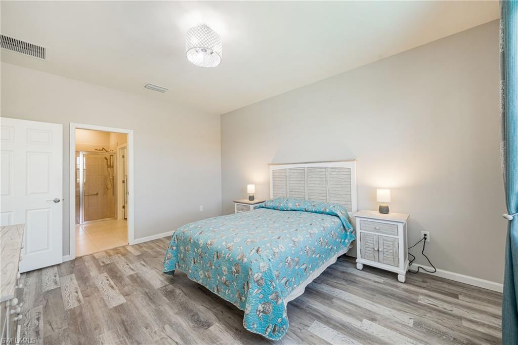 6125 Triumph Lane Ave Maria, FL 34142 - Photo 19 of 31 Bedroom featuring light wood-style floors and ensuite bath