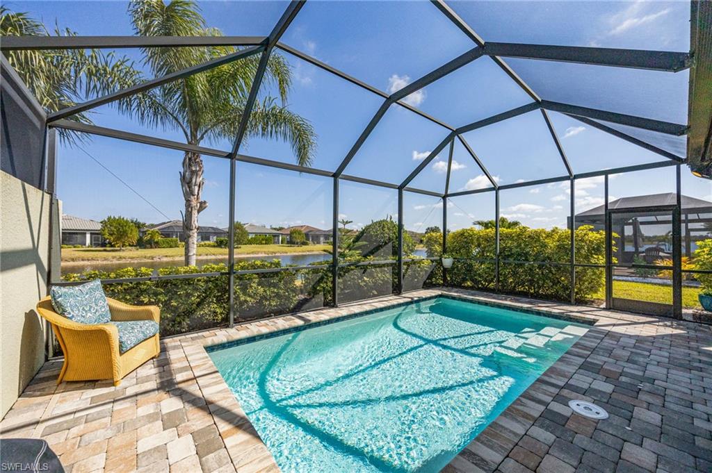 6125 Triumph Lane Ave Maria, FL 34142 - Photo 22 of 31 Outdoor pool featuring a sunroom, a lanai, a water view, and a patio area
