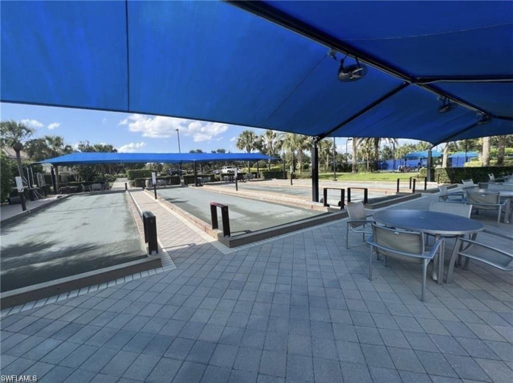 6125 Triumph Lane Ave Maria, FL 34142 - Photo 27 of 45 a view of a patio with table and chairs under an umbrella