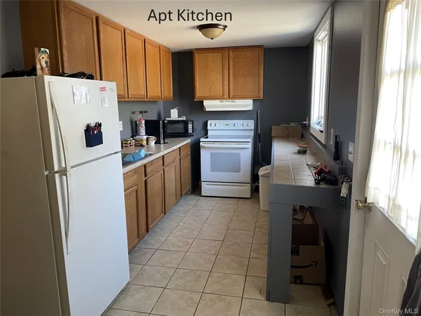 a kitchen with a refrigerator a stove top oven and cabinets