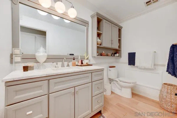 a bathroom with a toilet sink double vanity and mirror