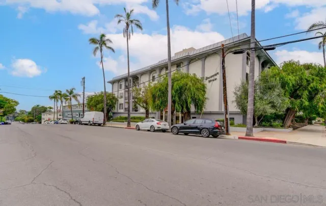 a view of a street with a building and a car parked in front of it