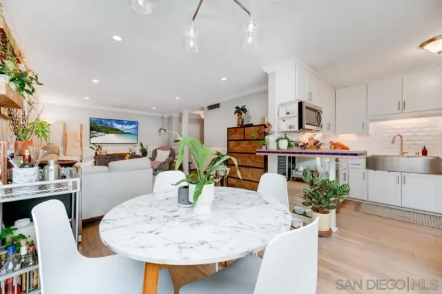 a kitchen with stainless steel appliances kitchen island granite countertop a sink a stove a dining table and chairs