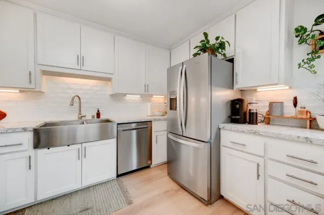 a kitchen with appliances a sink and a refrigerator