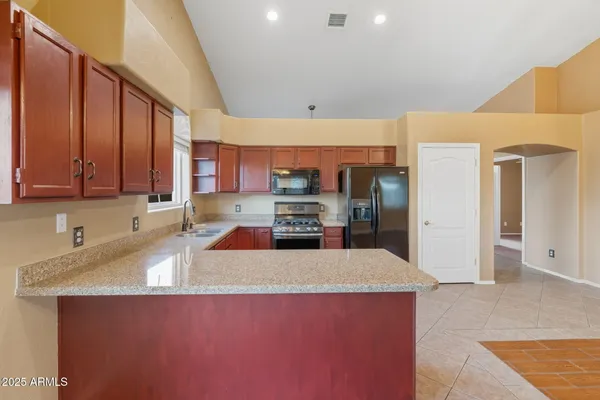a kitchen with stainless steel appliances granite countertop a sink stove and refrigerator