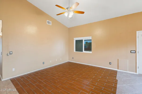 a view of a big room with a ceiling fan and a window