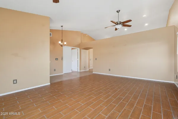 en empty room with wooden floor and ceiling fan