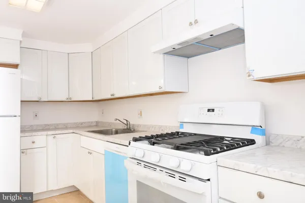 a white stove top oven sitting inside of a kitchen