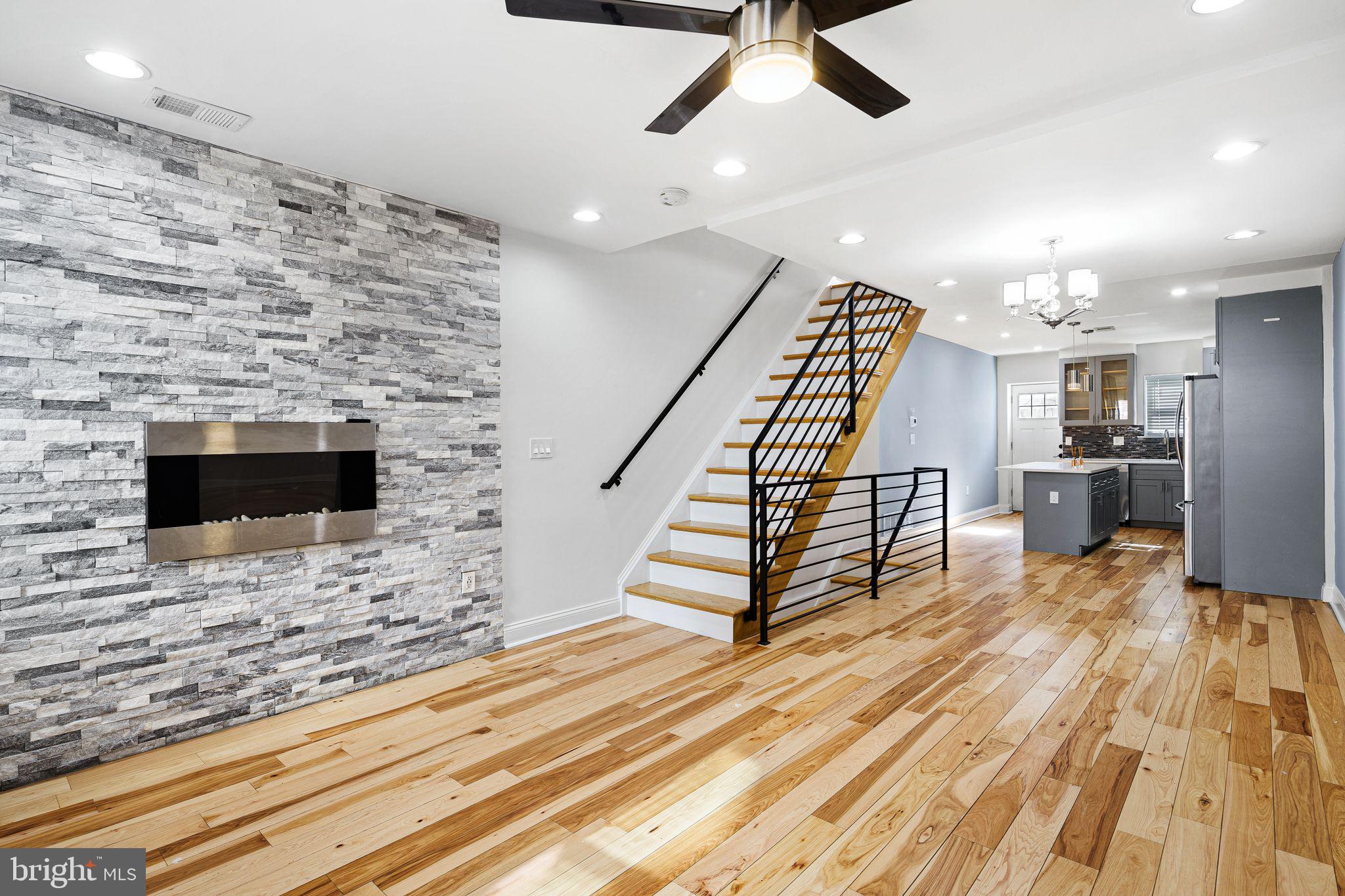 a view of a livingroom with wooden floor and staircase