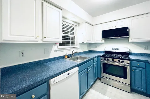 a kitchen with stainless steel appliances white cabinets and a refrigerator