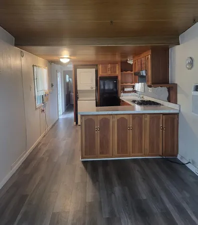 a kitchen with stainless steel appliances a kitchen island hardwood floor and a sink