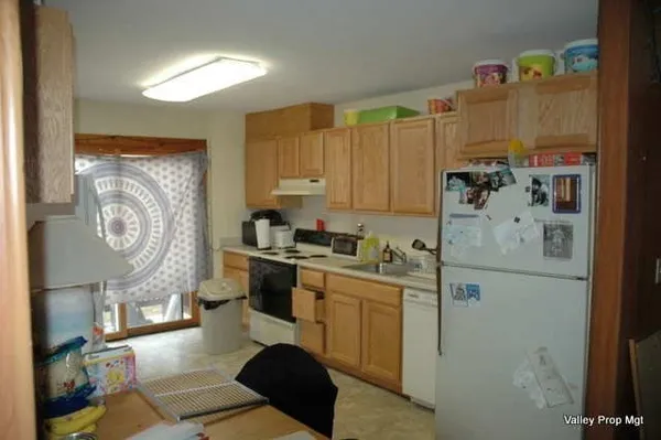 a kitchen with a refrigerator and a stove