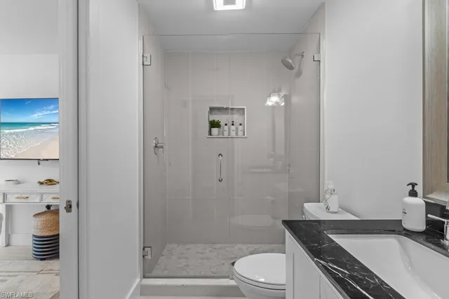a bathroom with a granite countertop sink toilet and shower