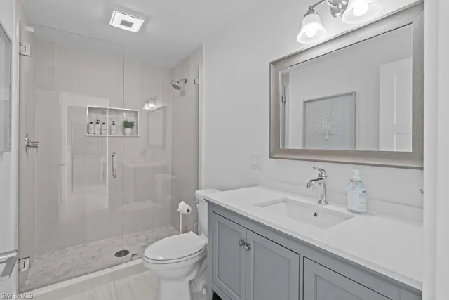 a bathroom with a sink a toilet and shower