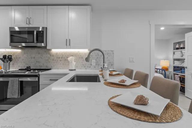 a kitchen with a sink a stove and cabinets