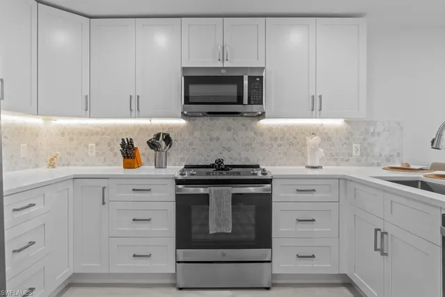 a kitchen with white cabinets and stainless steel appliances