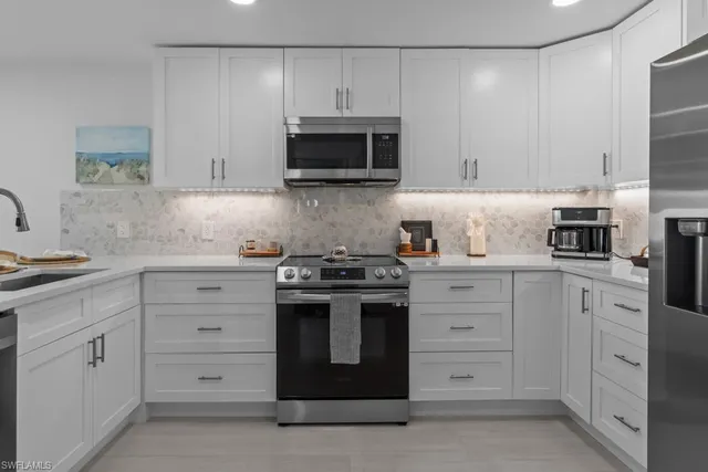 a kitchen with white cabinets and stainless steel appliances