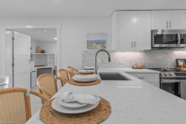 a kitchen with sink a stove and chairs