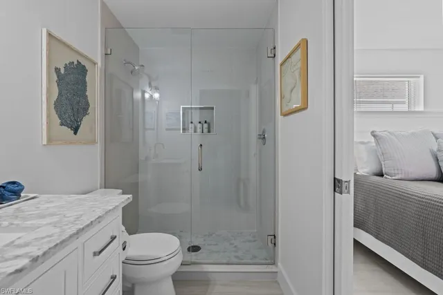 a bathroom with a granite countertop shower a toilet and a sink