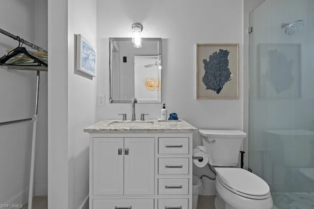 a bathroom with a granite countertop toilet sink and mirror