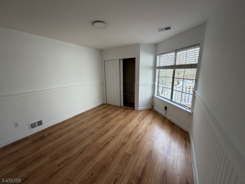 94 Wescott Road Bedminster, NJ 07921 - Photo 4 of 18 an empty room with wooden floor and windows