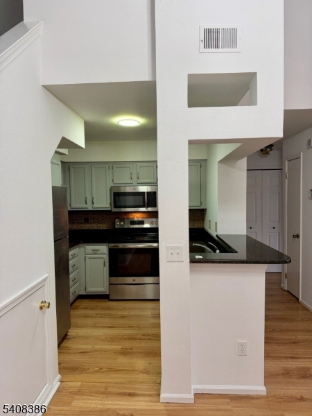 94 Wescott Road Bedminster, NJ 07921 - Photo 9 of 18 a kitchen with stainless steel appliances a sink and cabinets
