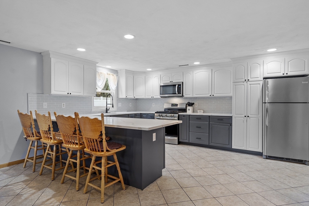 5 Elizabeth Road Billerica, MA 01821 - Photo 6 of 41 a kitchen with a refrigerator a table and chairs in it