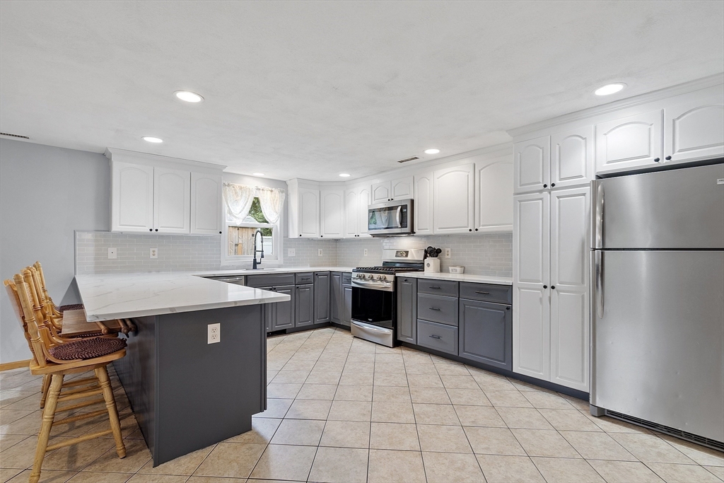 5 Elizabeth Road Billerica, MA 01821 - Photo 7 of 41 a kitchen with a sink a refrigerator and white cabinets
