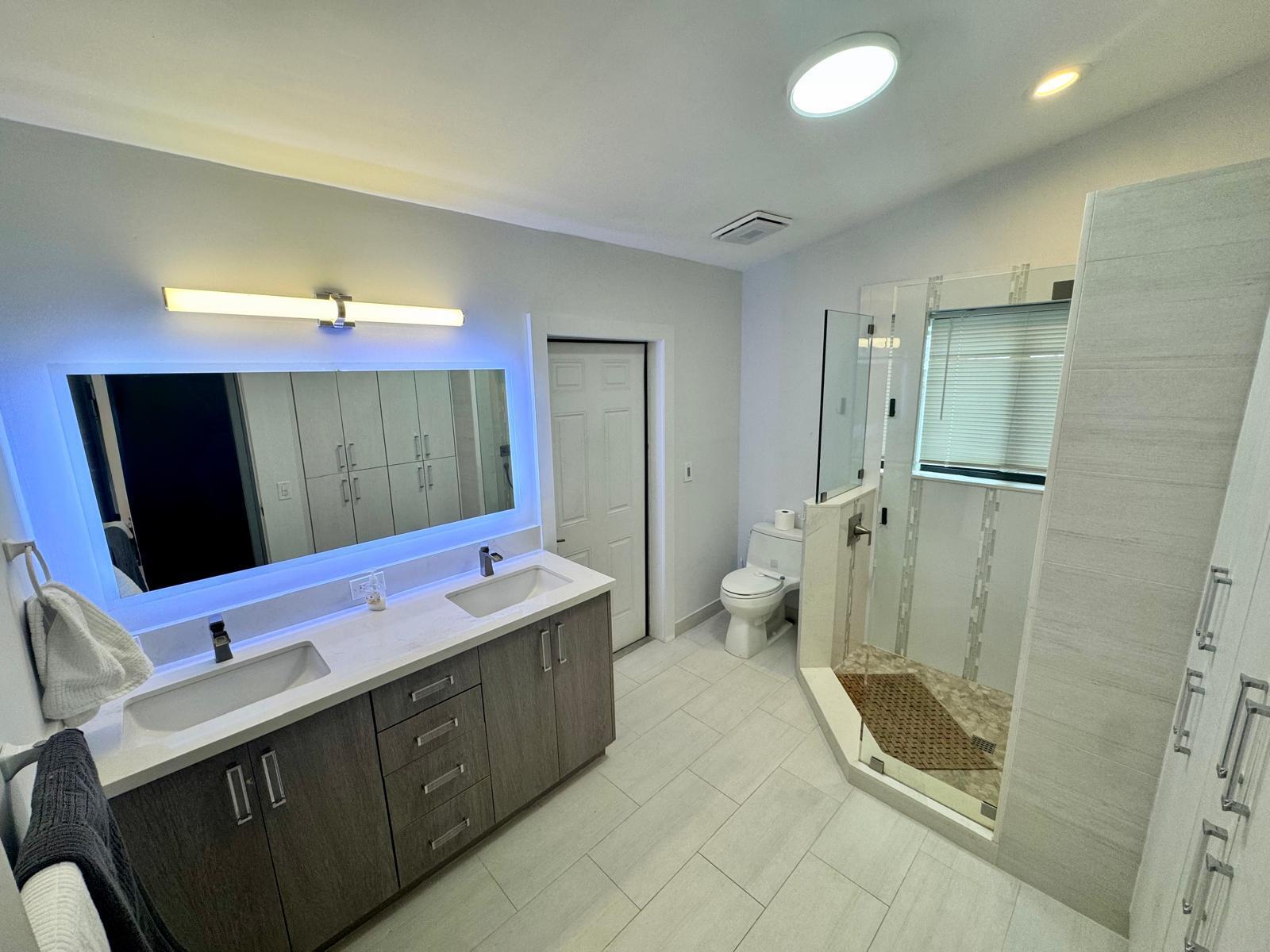 387 Enfield Street Boca Raton, FL 33487 - Photo 14 of 37 a bathroom with a sink and mirror with bathtub