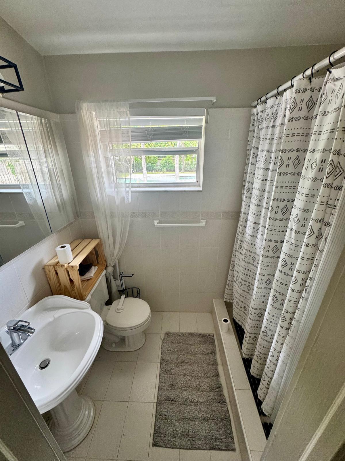 387 Enfield Street Boca Raton, FL 33487 - Photo 15 of 37 a white toilet sitting next to a bathroom sink and a tub