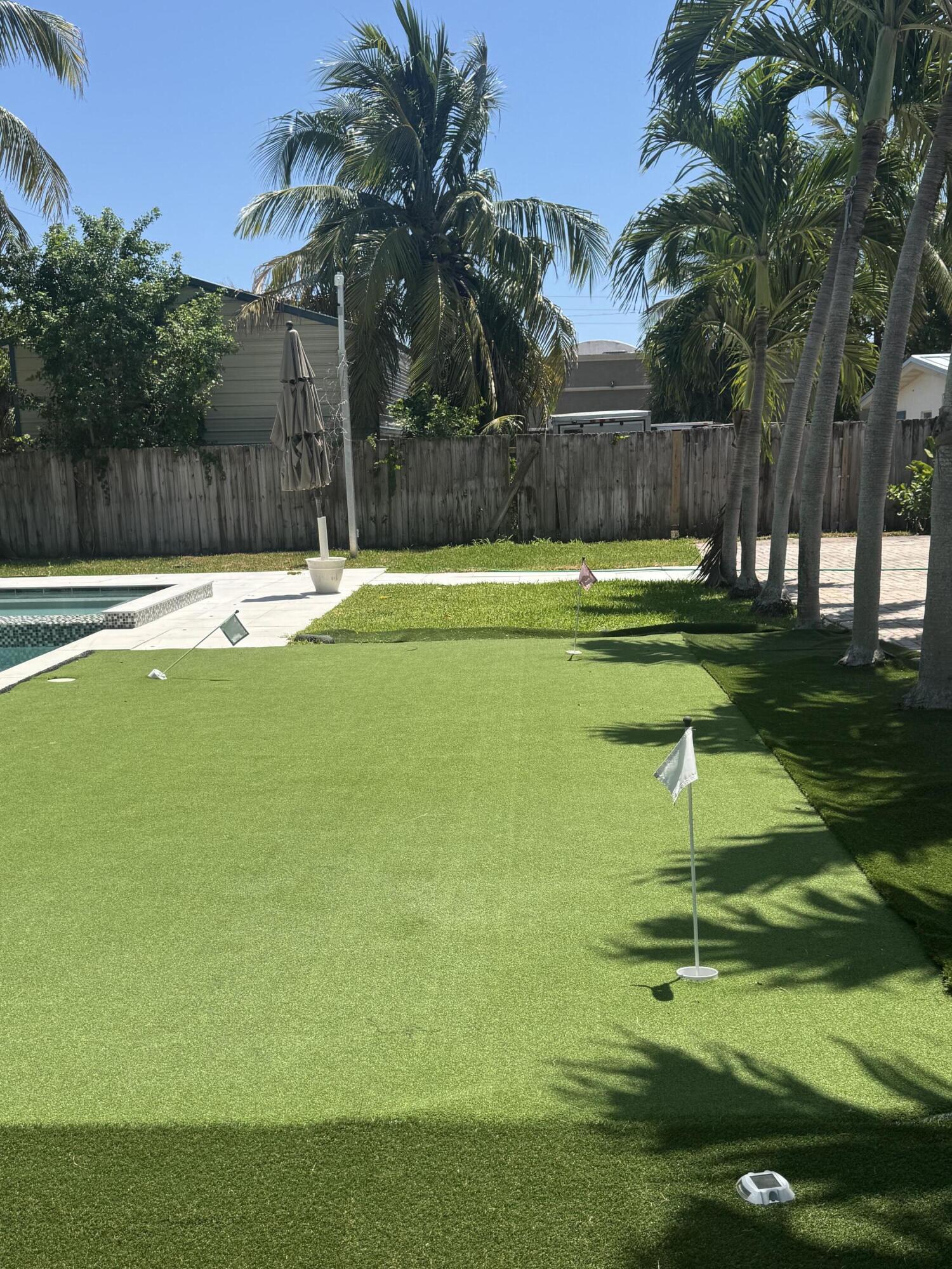 387 Enfield Street Boca Raton, FL 33487 - Photo 22 of 37 a swimming pool with outdoor seating and yard