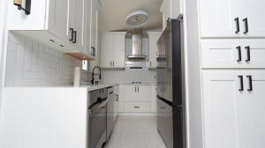 387 Enfield Street Boca Raton, FL 33487 - Photo 4 of 37 a kitchen with a sink and a refrigerator