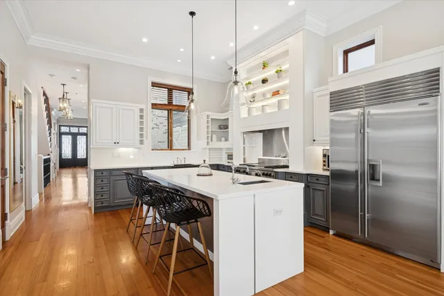 a kitchen with stainless steel appliances granite countertop a stove a refrigerator a oven a sink with island and wooden floor