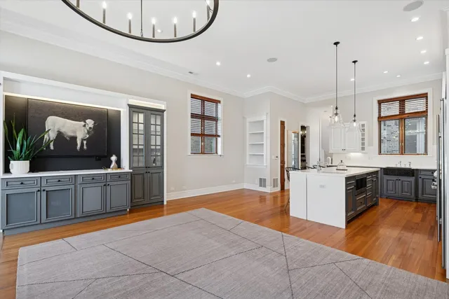 a large kitchen with kitchen island a stove a counter space a sink and a refrigerator