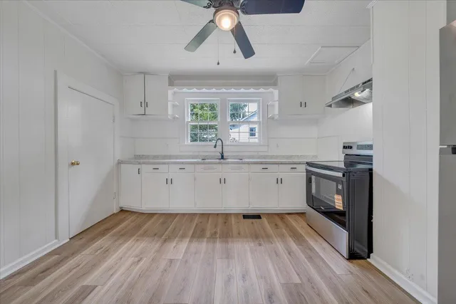 a view of a kitchen with a sink wooden floor and windows