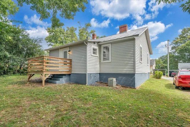 a view of a house with a yard and a tree