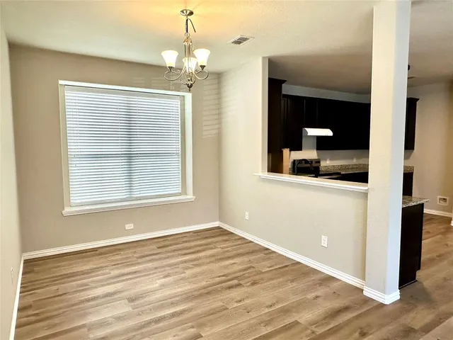 en empty room with wooden floor mirror and window