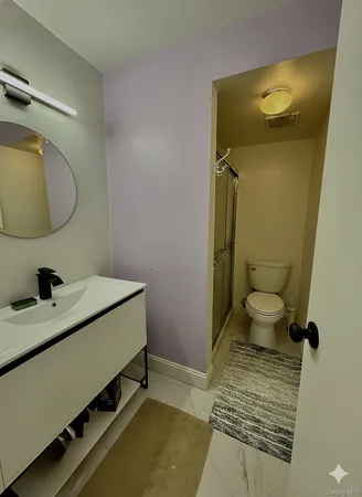 a bathroom with a granite countertop sink mirror vanity and toilet