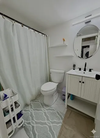a bathroom with a toilet a sink and a mirror