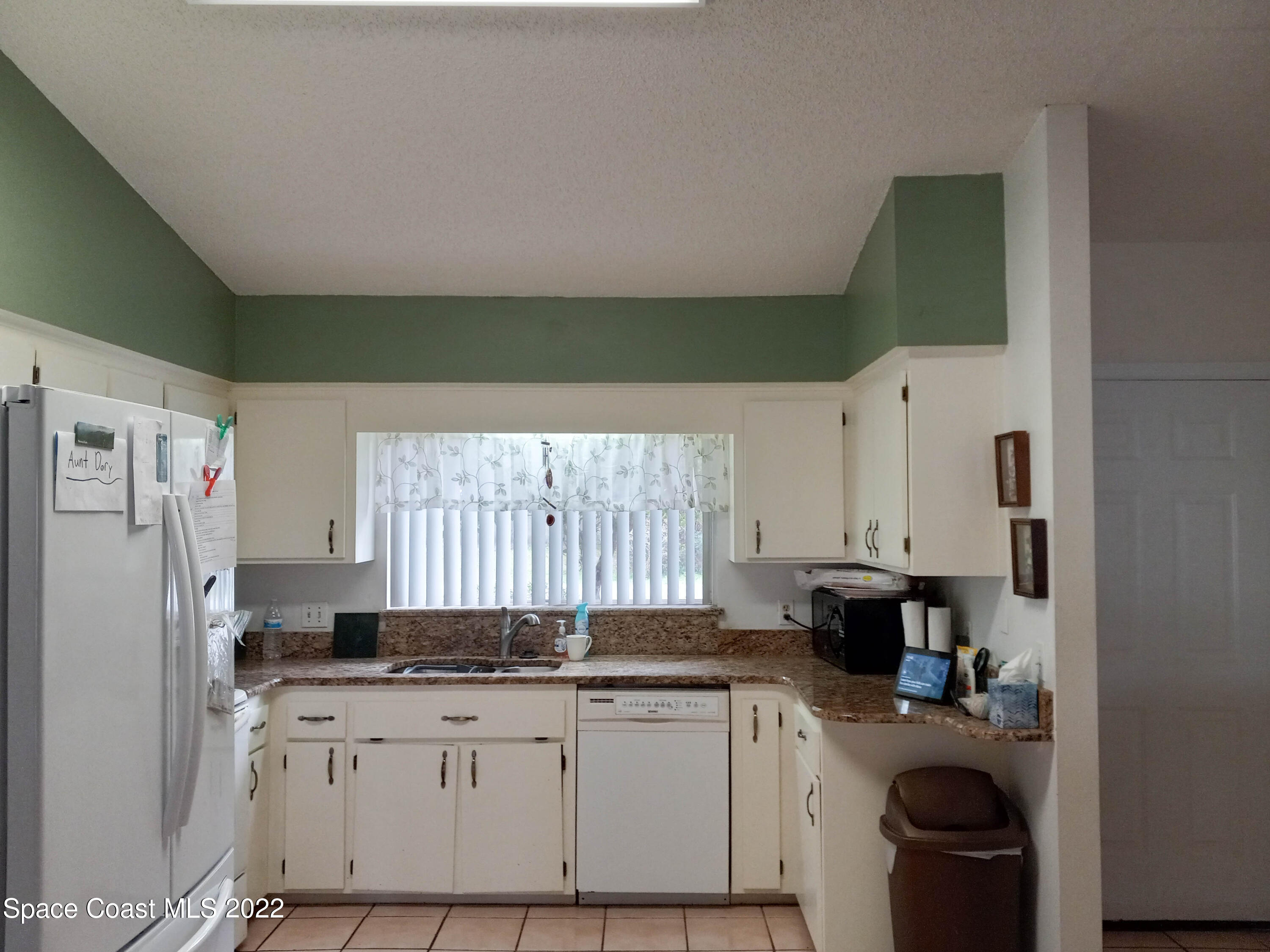 5166 Arlington Road Cocoa, FL 32927 - Photo 6 of 25 a kitchen with a sink a refrigerator and cabinets