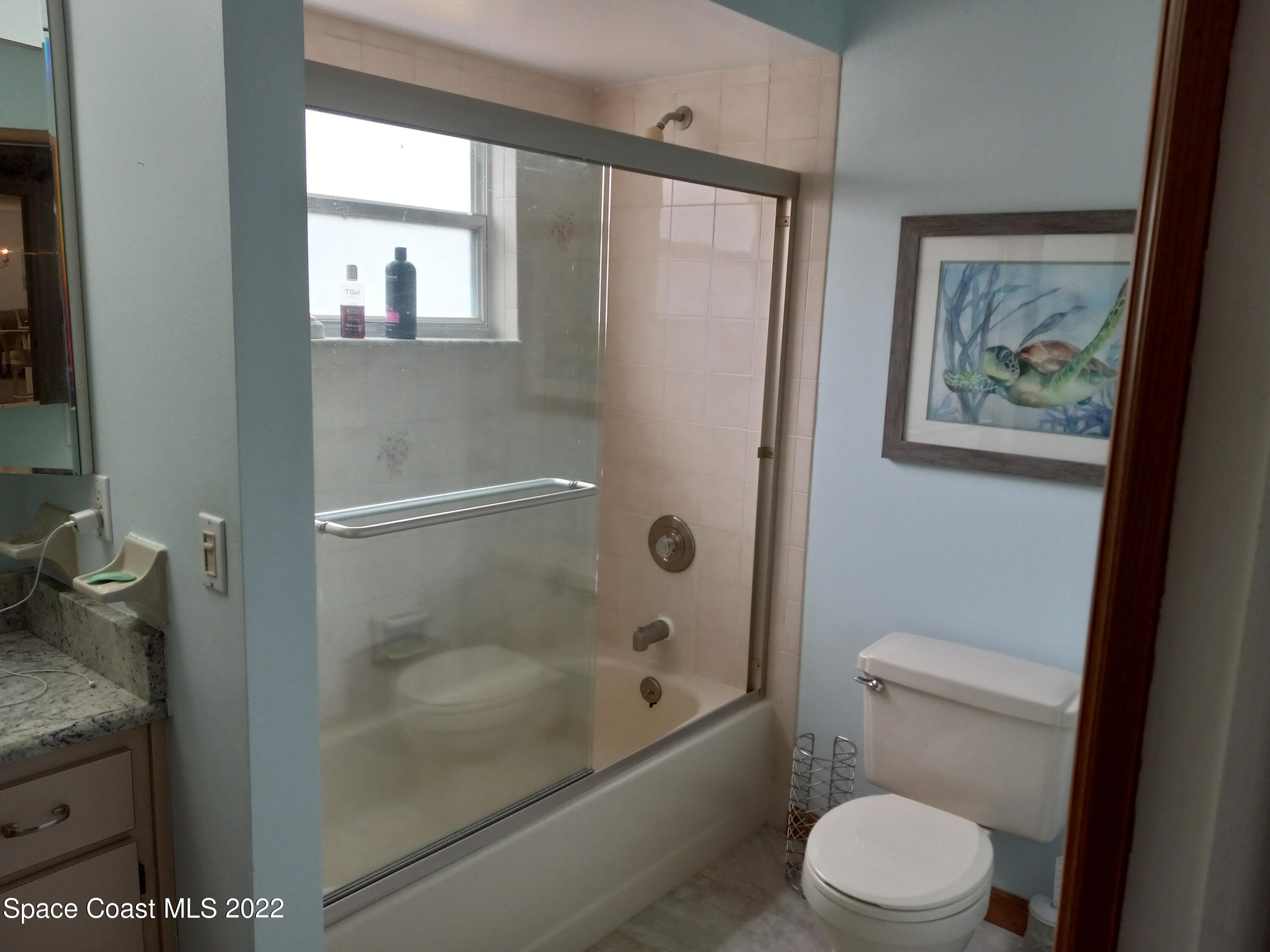 5166 Arlington Road Cocoa, FL 32927 - Photo 10 of 25 a bathroom with a granite countertop toilet a sink and bathtub