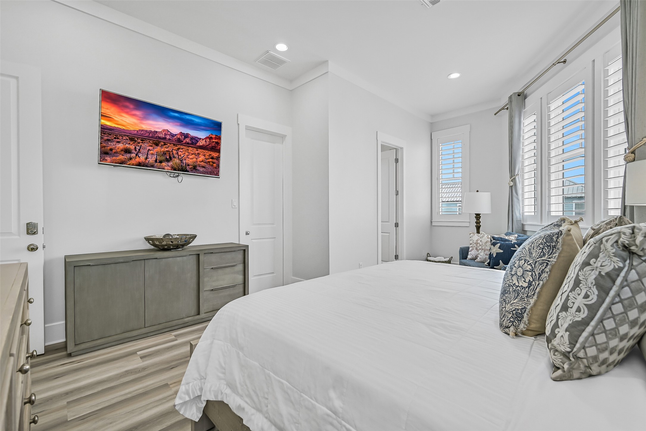 817 Positano Road Galveston, TX 77550 - Photo 23 of 50 Wake up refreshed in a beautifully updated primary suite where coastal comfort meets understated luxury. Enhanced with updated furnishings, new beach-inspired flooring, and a bright, airy atmosphere, this inviting retreat offers plenty of room to relax and unwind after a day by the shore.