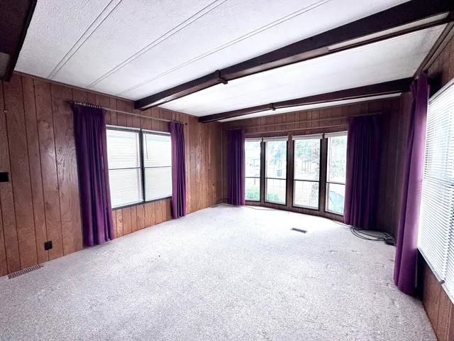 a view of an empty room with windows and closet