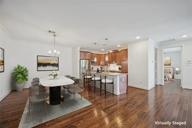 a kitchen that has a kitchen island a stove a wooden floor and a chandelier