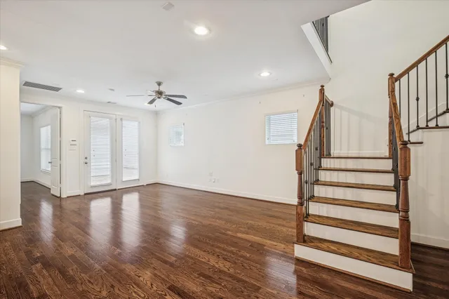 a view of a kitchen and an empty room with wooden floor