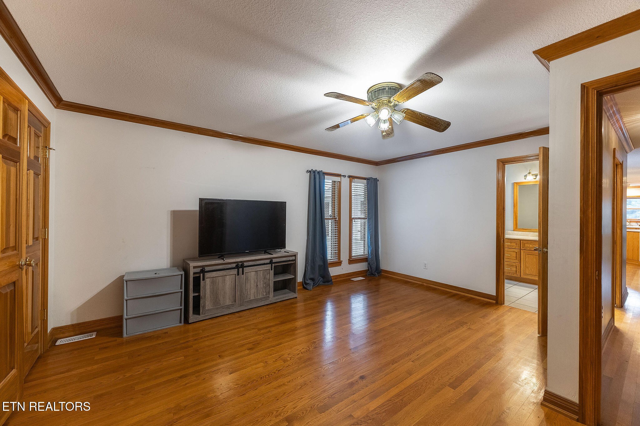 6251 Grimes Road Loudon, TN 37774 - Photo 14 of 43 a view of a livingroom with a flat screen tv wooden floor and a ceiling fan