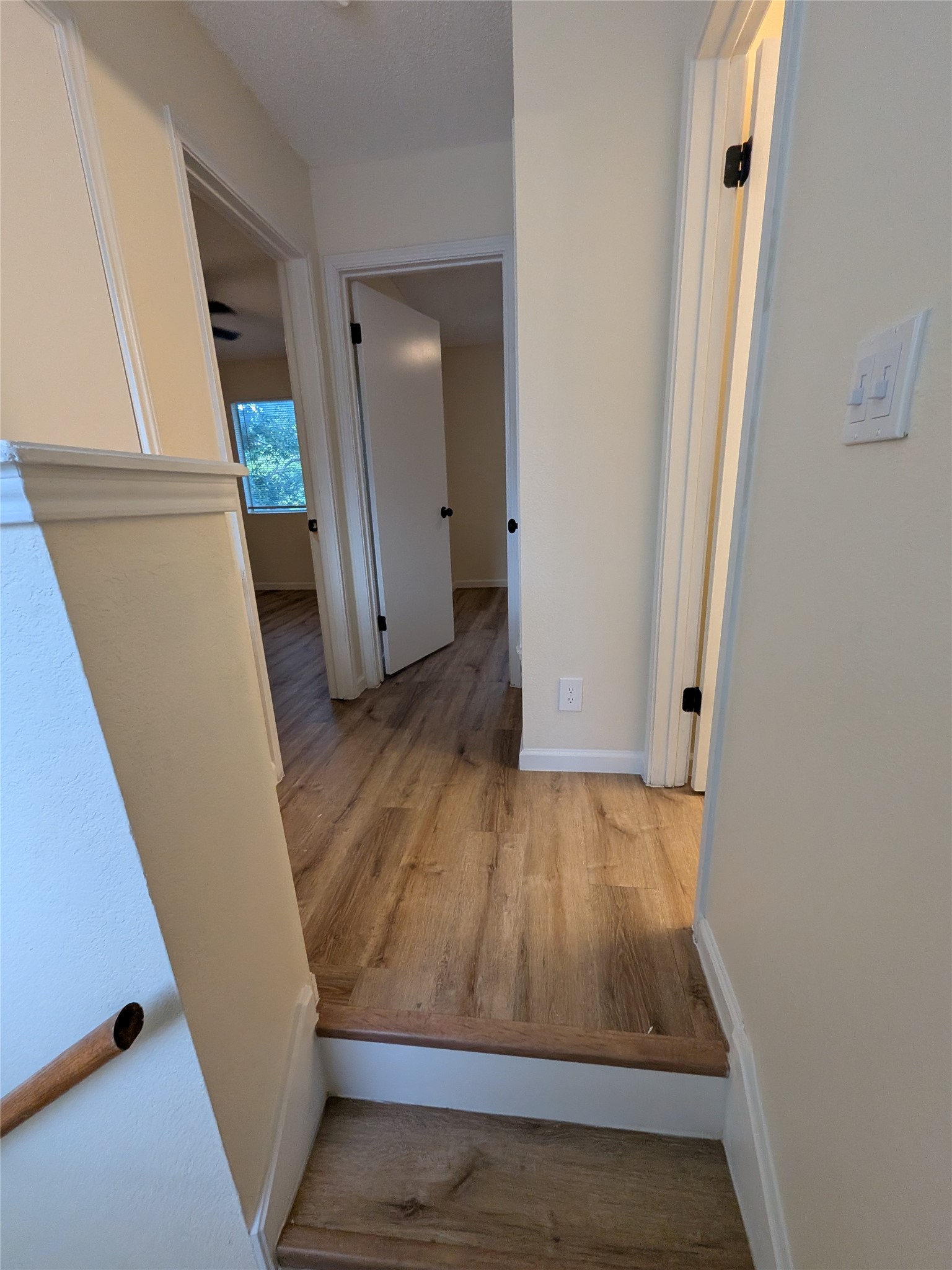 13303 Lyndhurst Street, Unit B Austin, TX 78729 - Photo 9 of 13 Steps lead to a welcoming hallway with durable hardwood flooring.