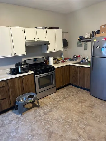 a kitchen with a sink a stove and cabinets