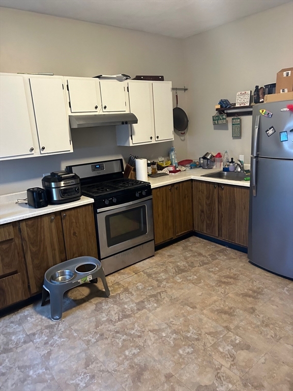 a kitchen with a sink a stove and cabinets